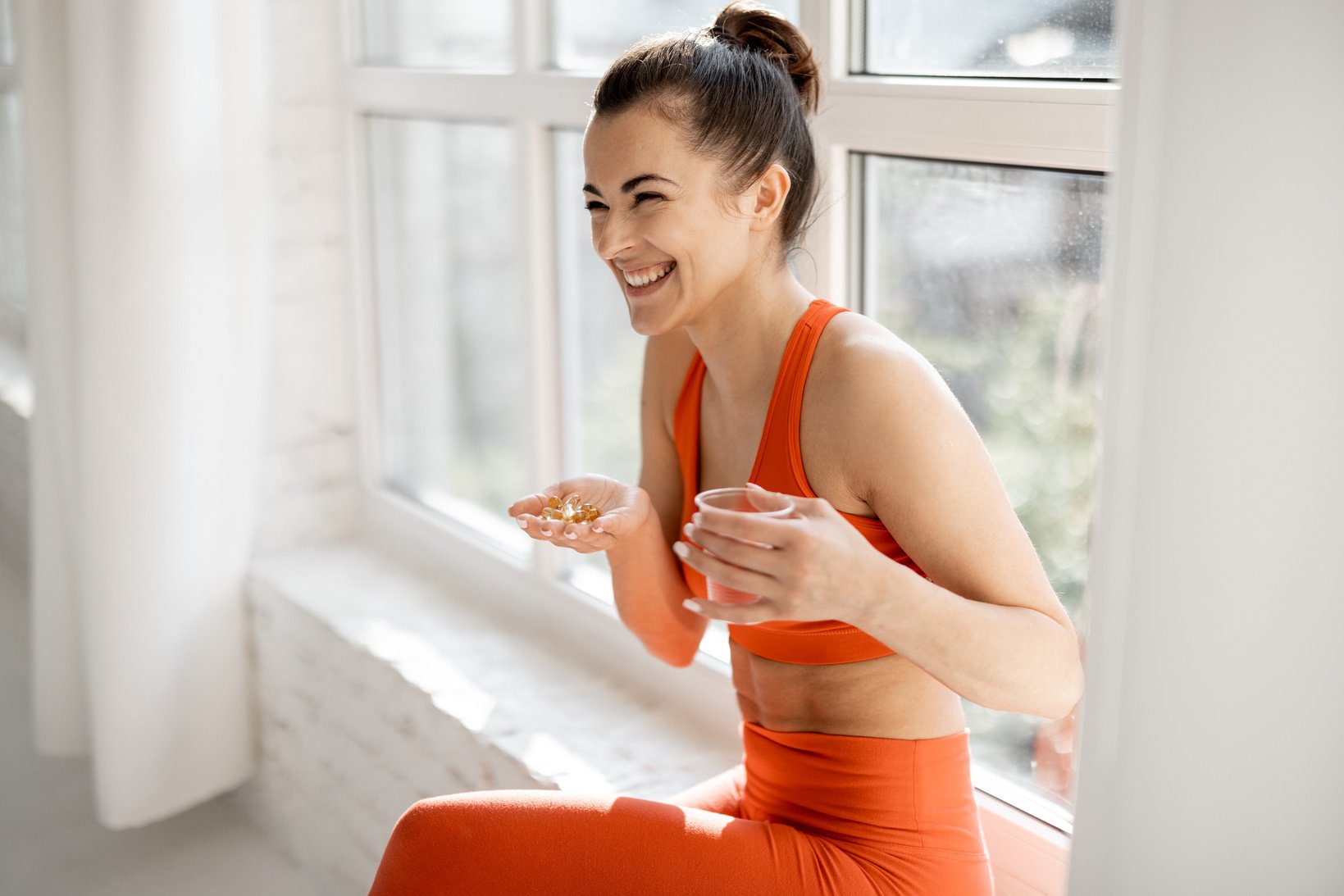 Sports woman takes supplements or vitamins at gym